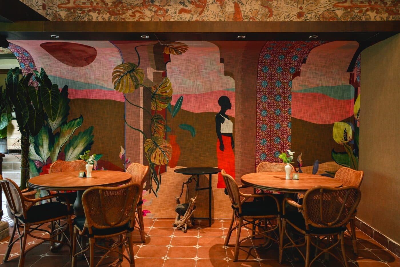 Close view of banquette seating and rattan chairs beside full-height garden windows at Tembusu