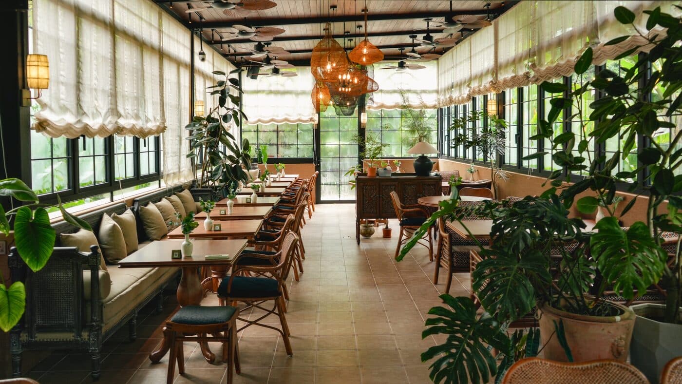 Second dining hall at Tembusu with woven pendant lamps, potted plants and timber-framed windows