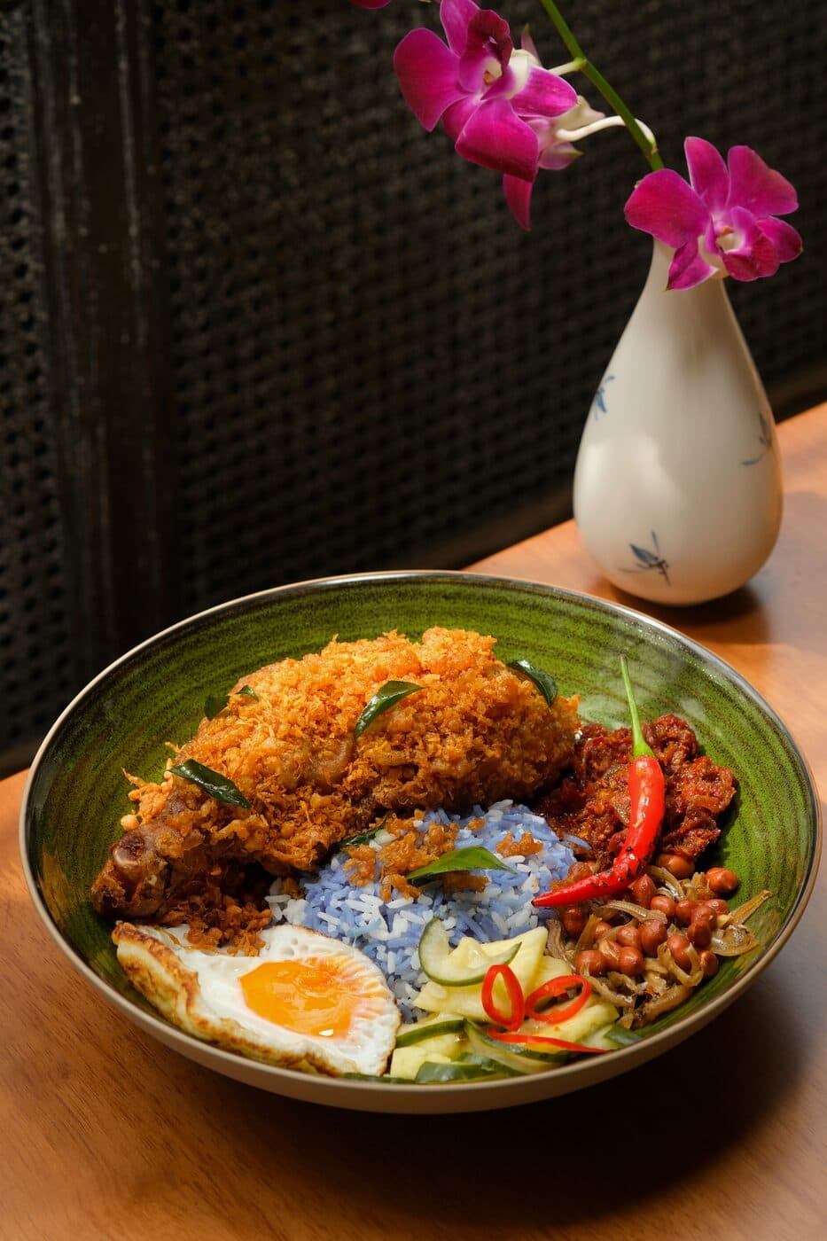 Nasi lemak plated with fried chicken, egg, sambal and anchovies at Tembusu