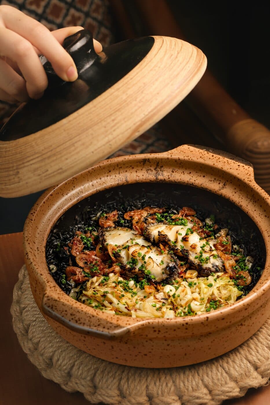 Squid ink claypot rice served in a wooden-lidded claypot at Tembusu