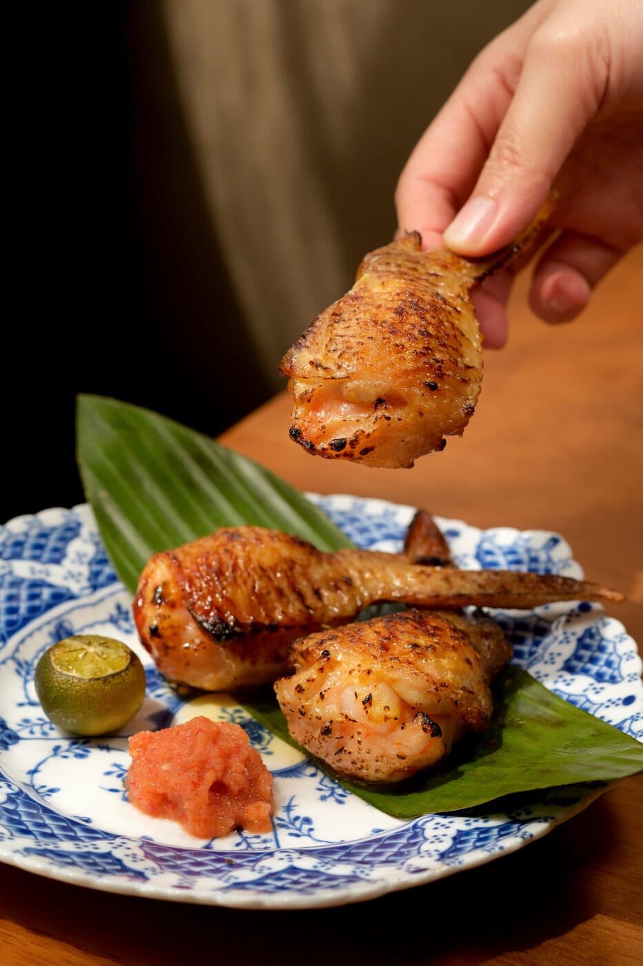Stuffed chicken wings on a banana leaf with dipping sauce at Tembusu