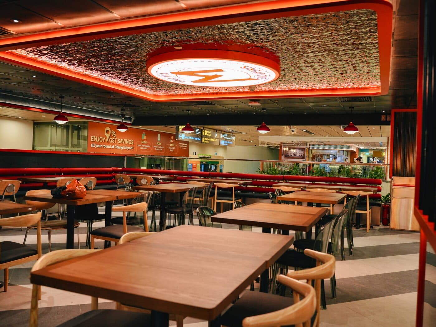 Dining area with rows of timber tables and rattan-textured ceiling